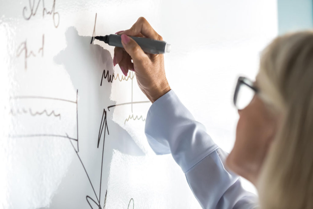 Woman writing on whiteboard